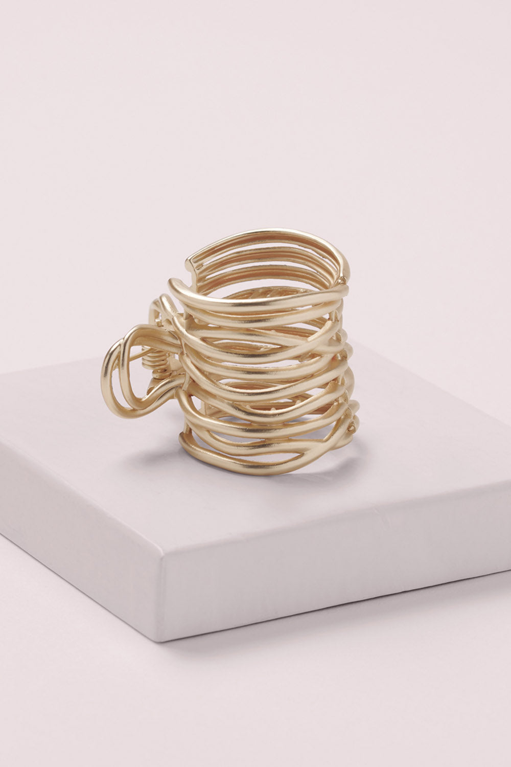 Gilded Wrap Cuff Claw Clip on a pink box