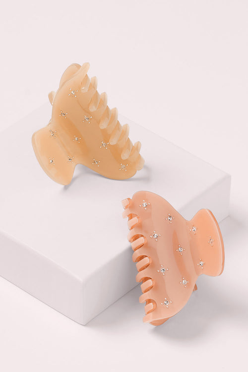 The Hair Edit Small Star Studded Rhinestone Claw Clips two pack on a pink box