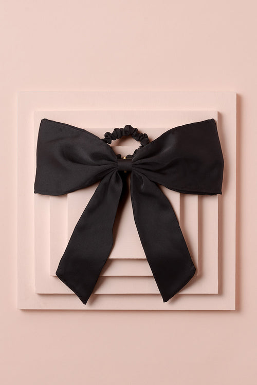 Runway Ribbon Satin Hair Bow Clip on a stack of pink boxes