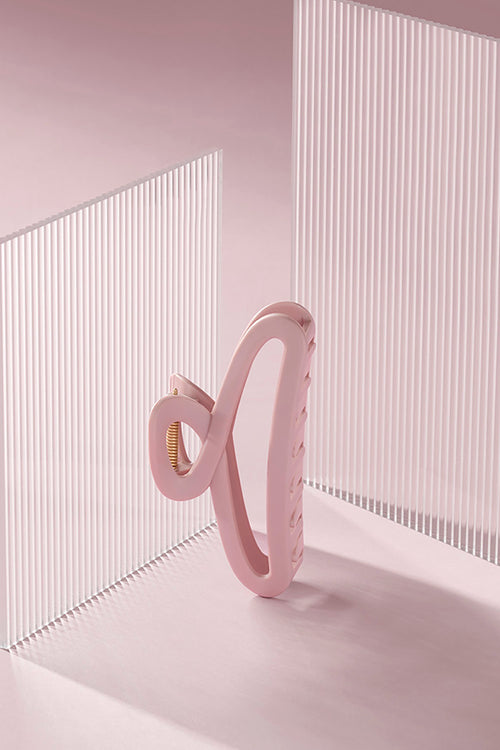 Pink claw clip against a pink background