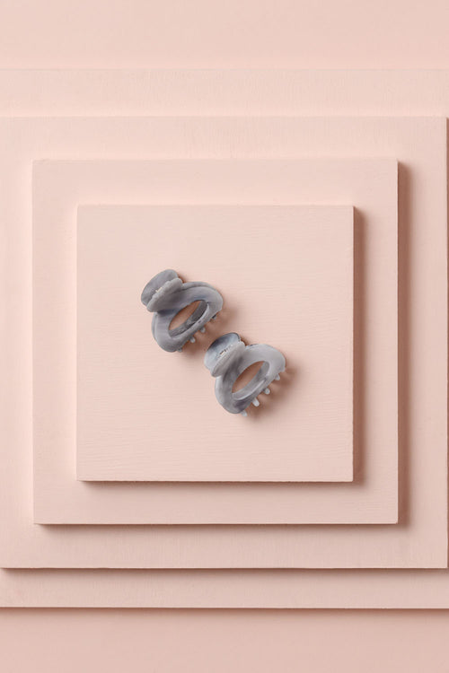 Petite Marble Claw Clips on a stack of pink boxes