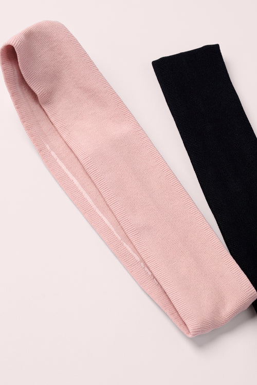Pink and black headbands on a light gray background