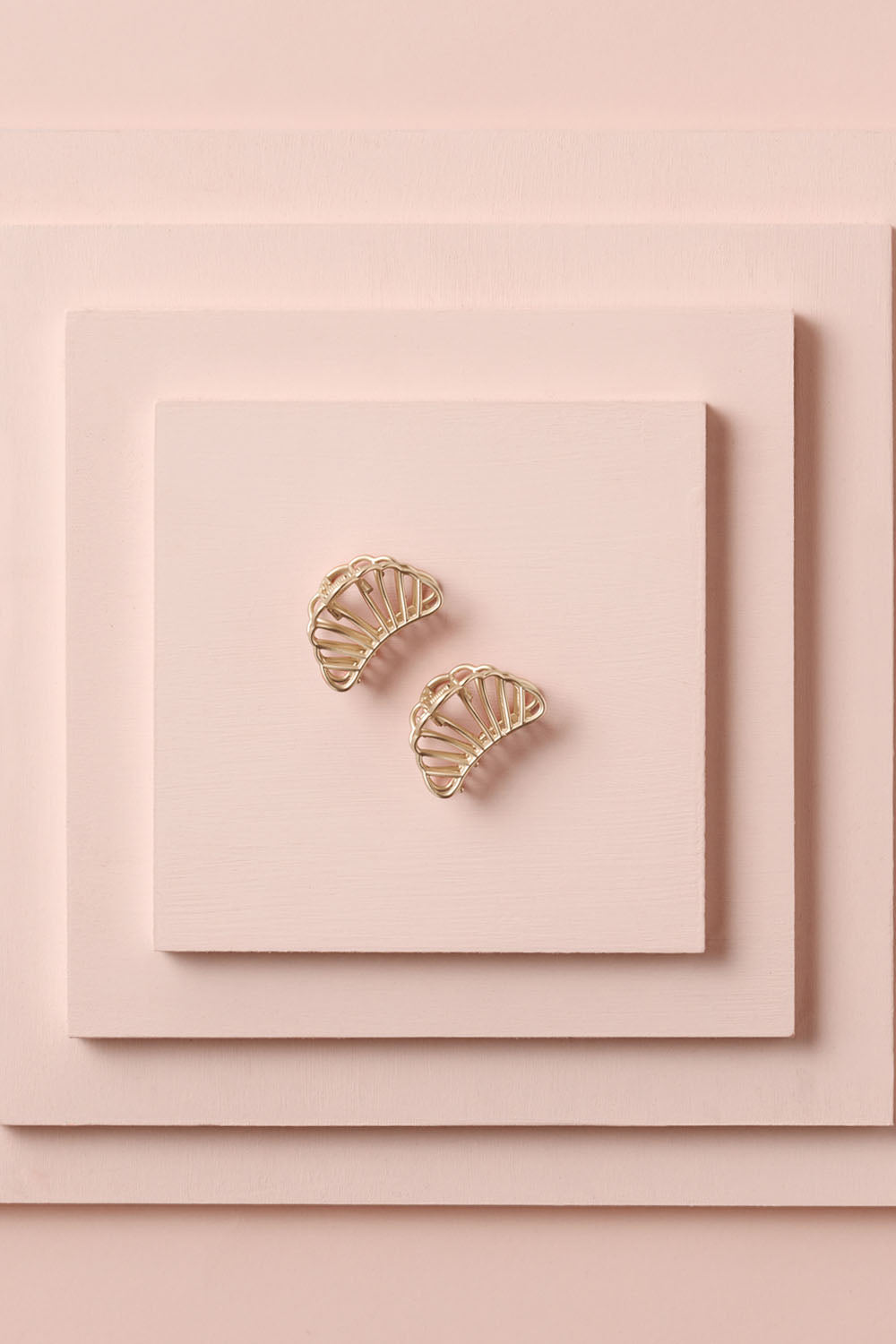 Petite Gilded Mermaid Claw Clips on a stack of pink boxes