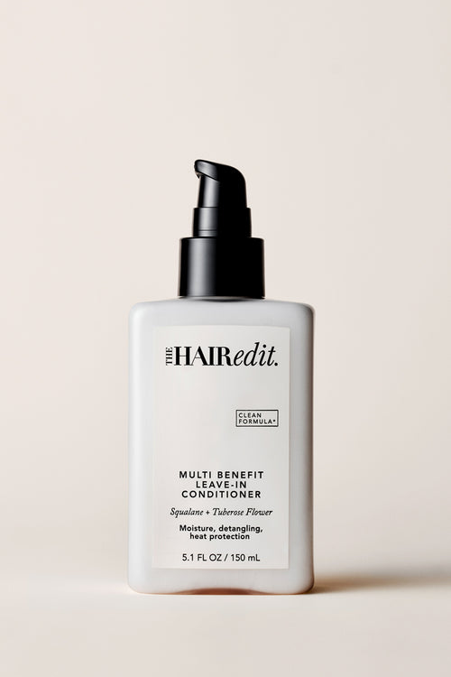The Hair Edit Multi Benefit Leave-In Conditioner Spay Bottle on a Beige Background