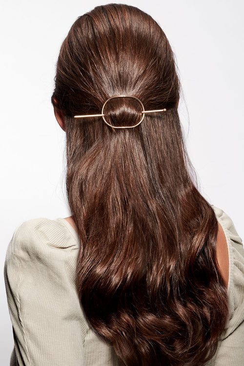 brunette model with hoop and pin barrette in hair