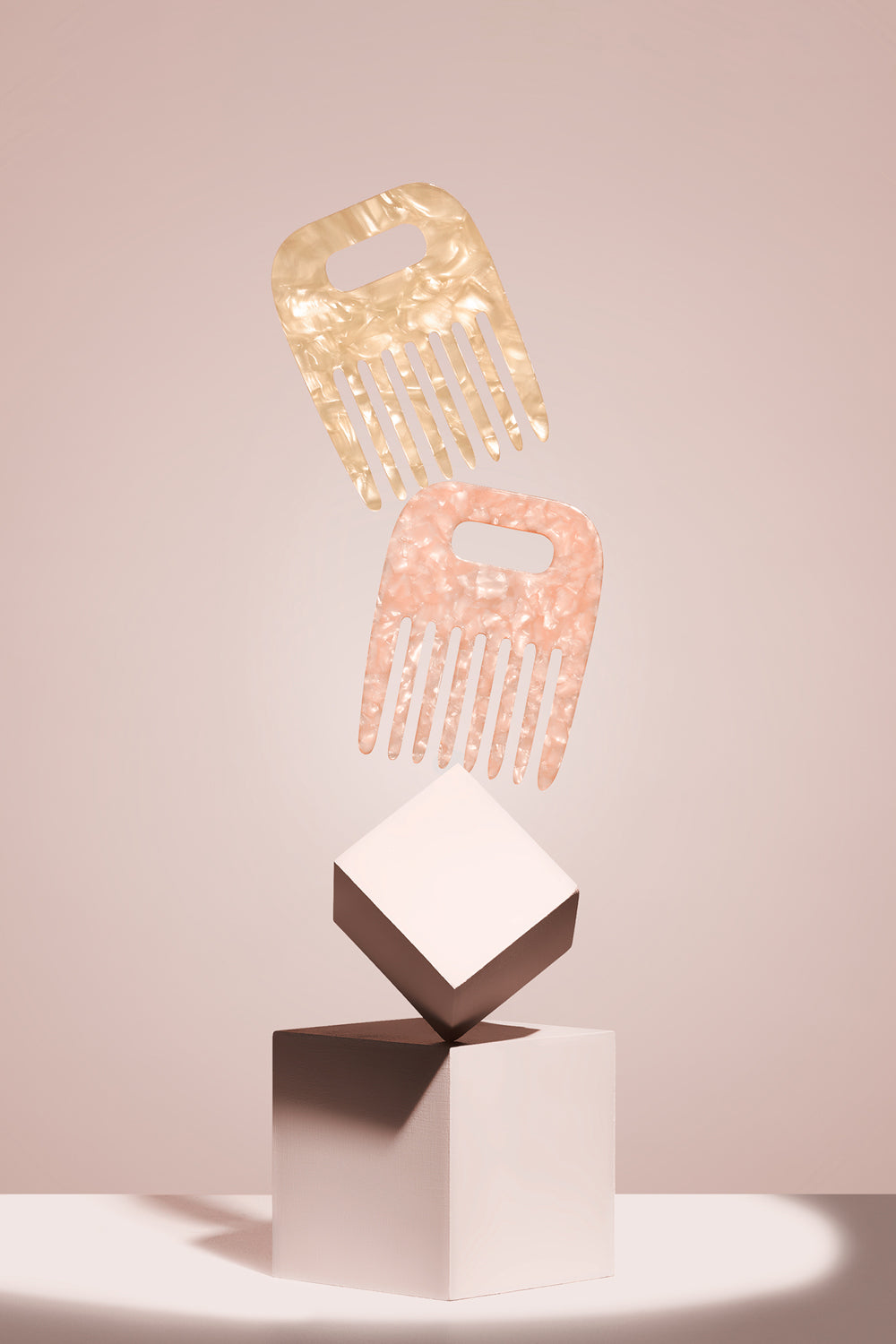 The Hair Edit Untangle & Glide 2 marble cooling & detangling mini combs on a pedestal
