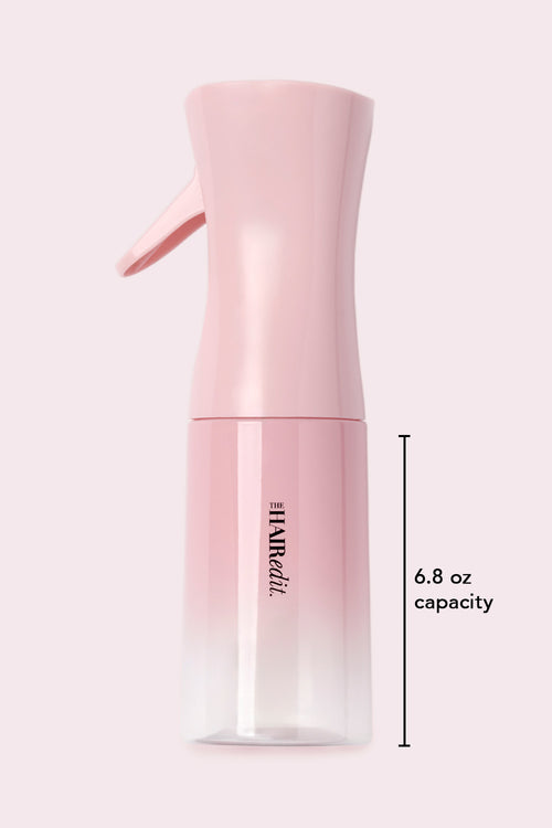 Pink spray bottle with 'The Hair Edit' branding and 6.8oz capacity label on a light pink background