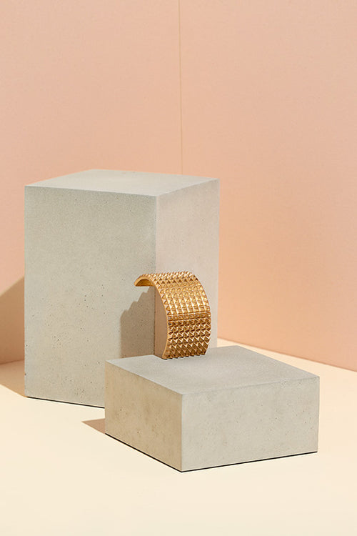 The Hair Edit Hair Accessories Ponytail Studded Cuff Textured Metal Hair Tie in Soft Gold Color on Pink Display