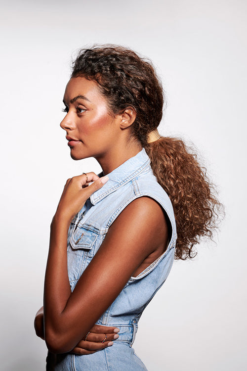 The Hair Edit Hair Accessories Ponytail Studded Cuff Textured Metal Hair Tie in Soft Gold Color styled in ponytail & worn by curly hair dark brunette model