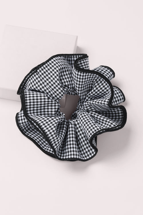 Black and white gingham oversized ruffled scrunchie on a pink background