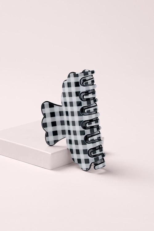 Black and white gingham scalloped claw clip on a pink background