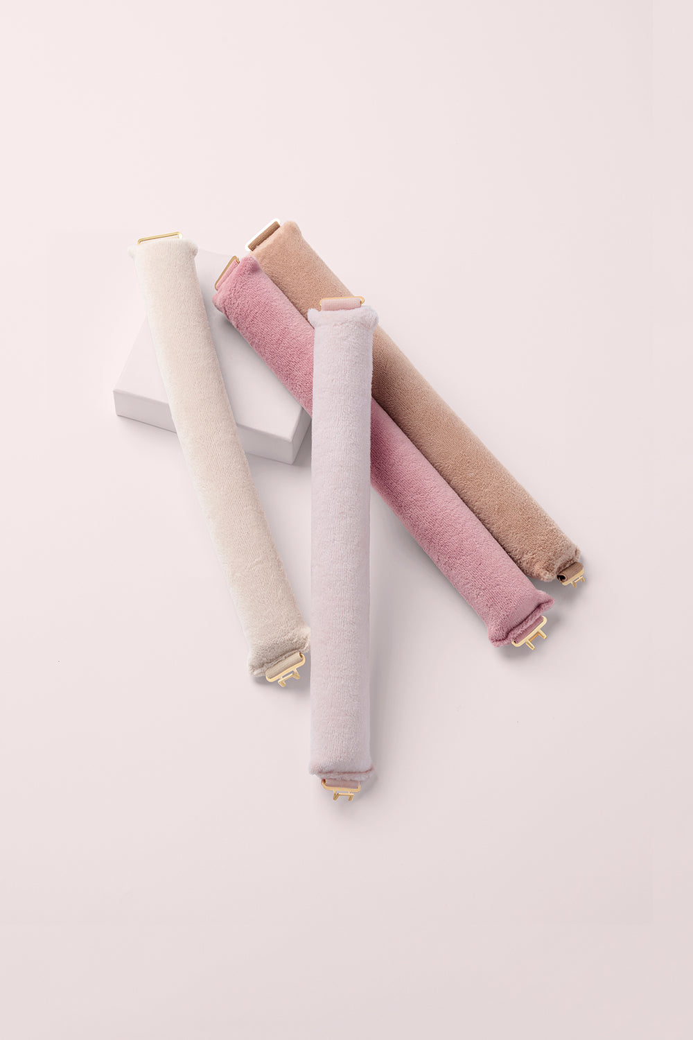 The Hair Edit Heatless Volumizing Hair Rods 4 Pack on a pink box with a pink background1