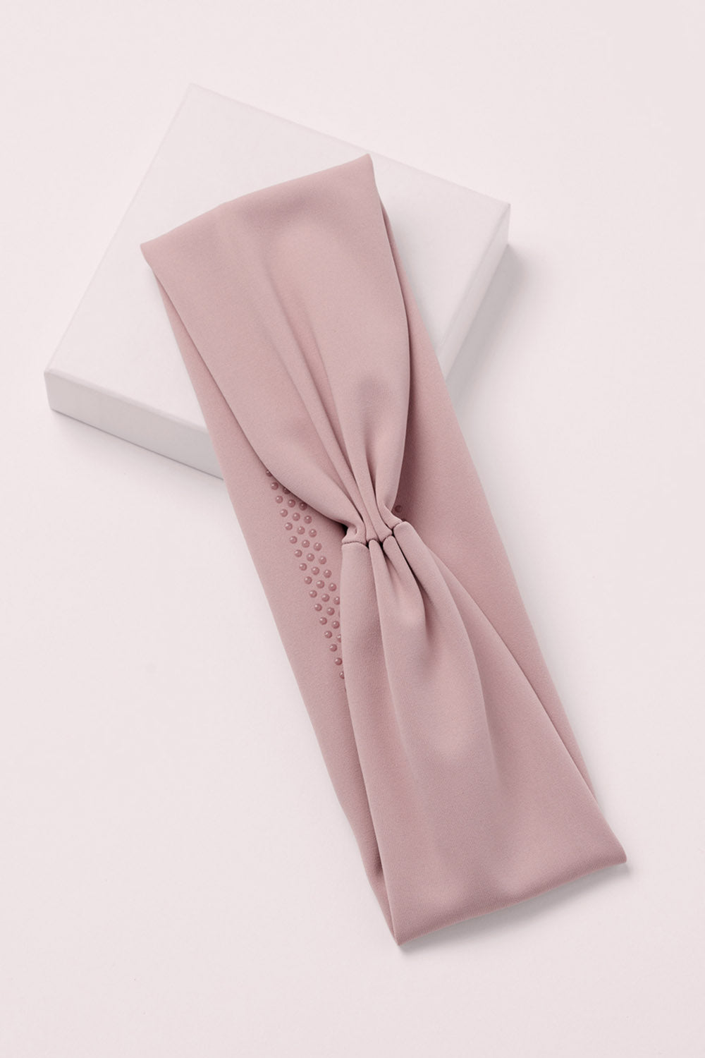 Lotus Soft Pleated Headband on a pink box 