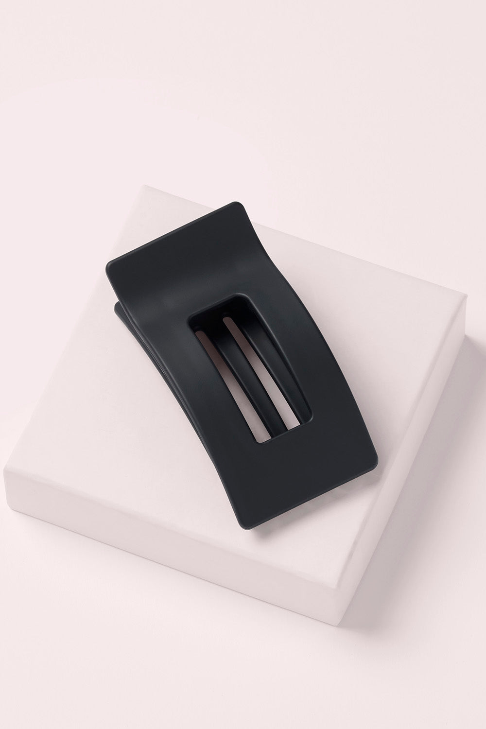 Black rectangular flat lay claw clip on a pink box1