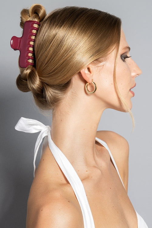 A blonde model wearing the Scarlet Red Claw Clip in a French twist hairstyle 