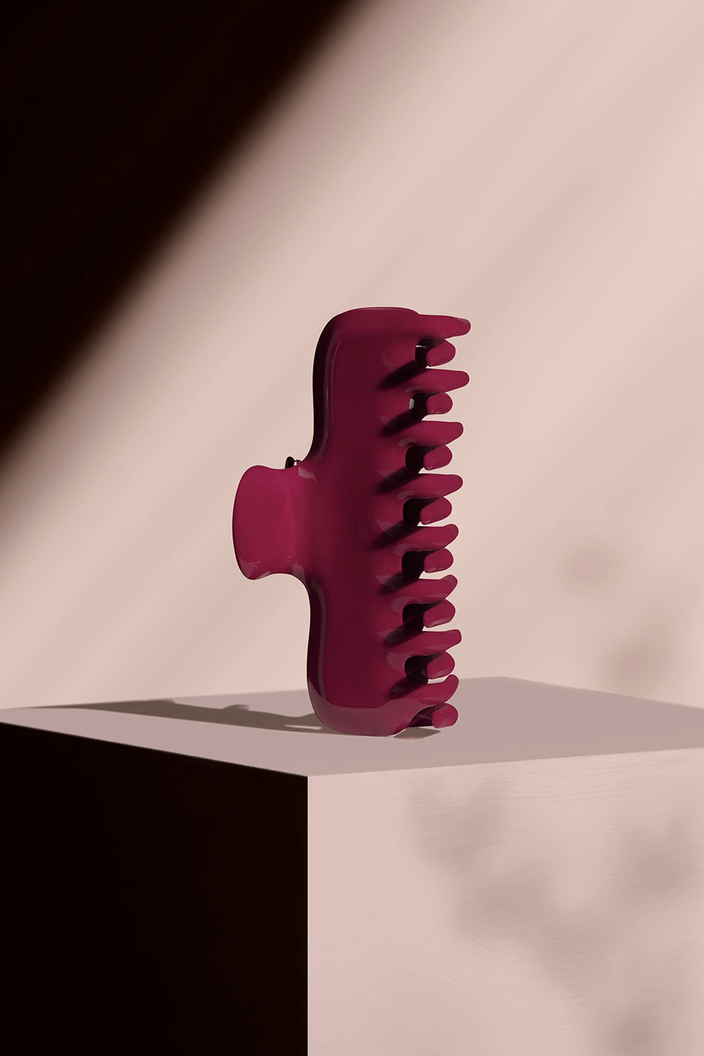 Red Scarlet Claw Clip on a pink pedestal with a pink background 4