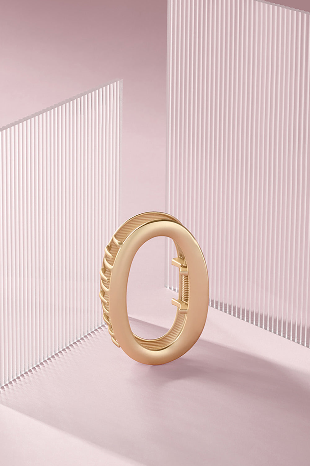 The Hair Edit Gilded Contour Claw Clip against a pink background 4