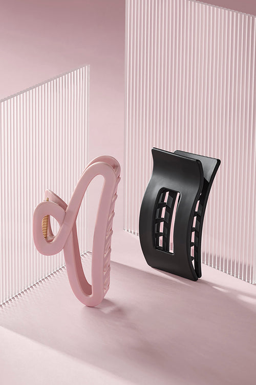 Pink triangle claw clip and black rectangle flat lay claw clip against a pink background