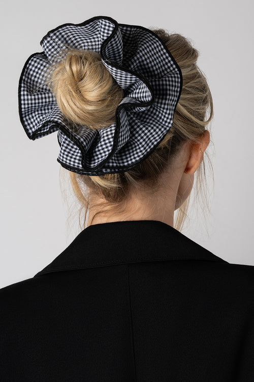 Blonde model wearing Black and white gingham oversized ruffled scrunchie in her hair in a bun