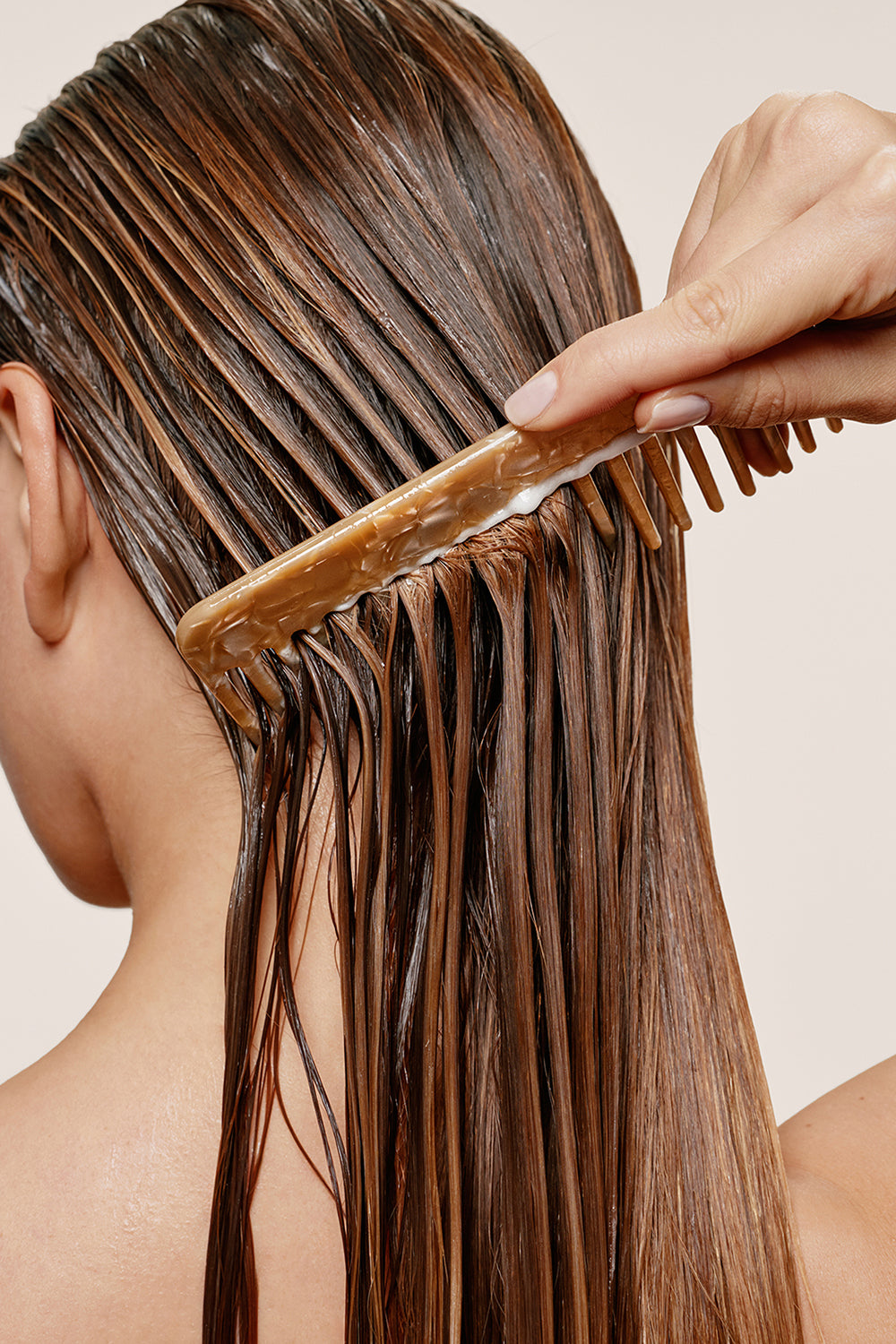 Model combing conditioner through her wet hair7