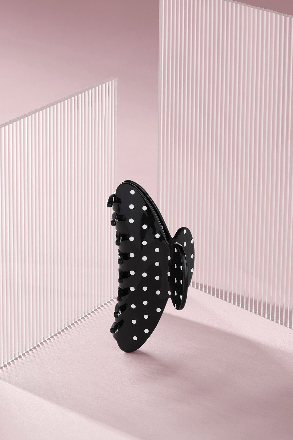 Black polka dot claw clip on a pink background8