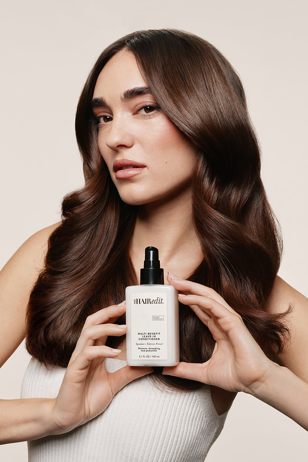 Model holding The Hair Edit Multi Benefit Leave-In Conditioner Spay Bottle in her hands9