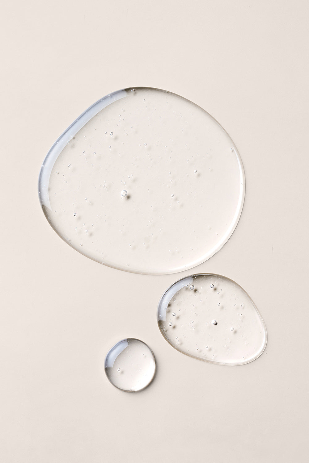 Close up of three round hair oil droplets6