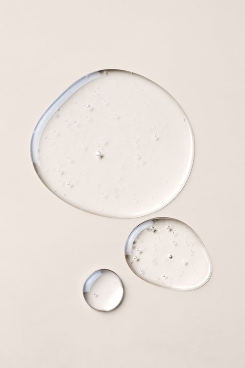 Close up of three round hair oil droplets