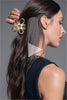 A video of a model putting Gilded Secret Garden Flower Claw Clip in her hair 