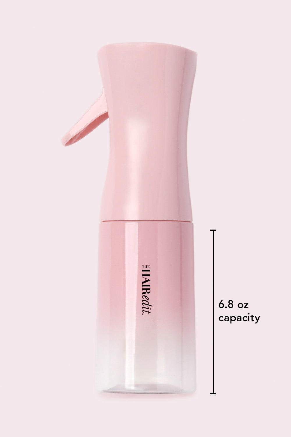 Pink spray bottle with 'The Hair Edit' branding and 6.8oz capacity label on a light pink background5